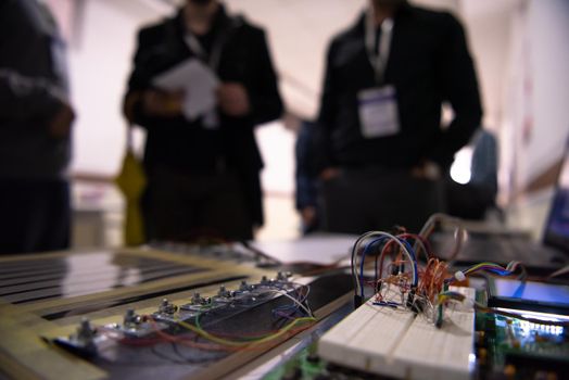 high technology electric circuit motherboard with team of computer engineers in background