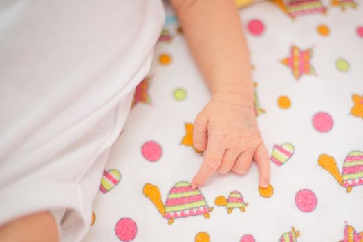 hand of a sleeping newborn baby lying a baby blanket
