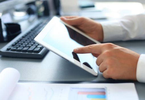 Image of human hand pointing at touchscreen in working environment at meeting