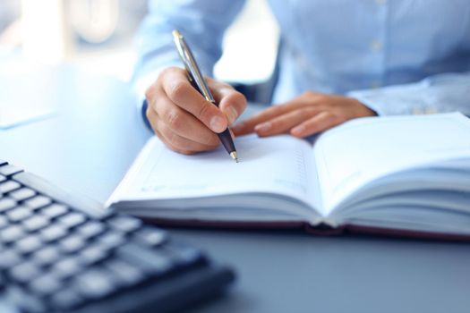 Business lady taking business notes at office