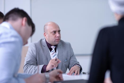 Group of a young business people brainstorming and discussing business plan on meeting at startup office interior