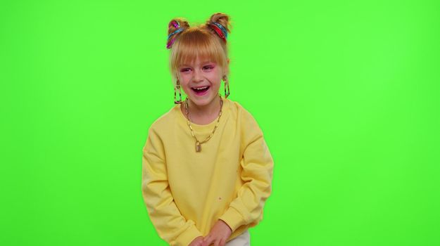 Happy funky young female blogger child kid girl, recording funny dancing video on smartphone for social network or personal channel, having fun entertaining on weekend at home on chroma key background