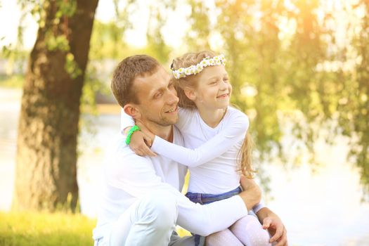 fatherhood - happy father and little daughter hugging each other in the Park on a Sunny day