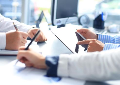 Unrecognizable business person analyzing graphs and taking notes