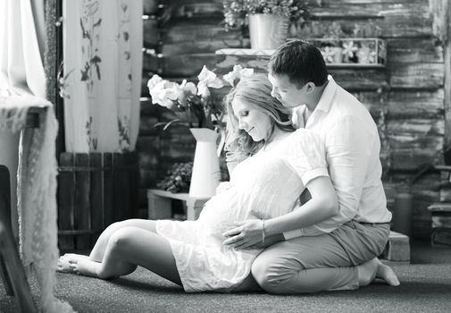 Portrait of a happy couple - husband and pregnant wife, black-and-white photo