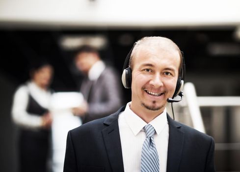 Young customer service operator talking on headset, smiling.