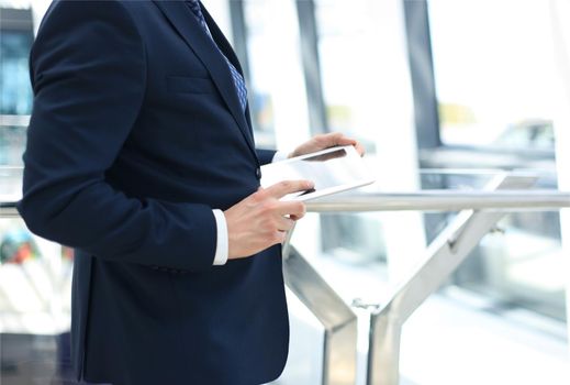 Midsection of businessman using digital tablet in office