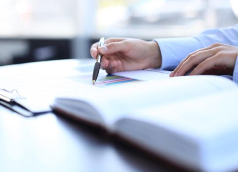 Businesswoman makes a note in notebook.