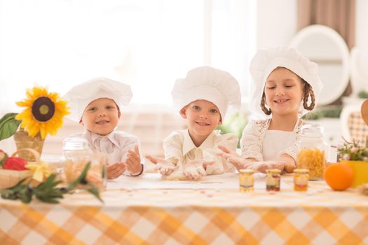 happy little children in the form of a chef to cook a delicious breakfast the kitchen