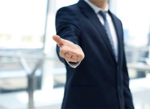 businessman standing in an office and reaching out