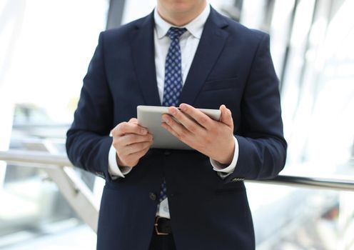 Midsection of businessman using digital tablet in office