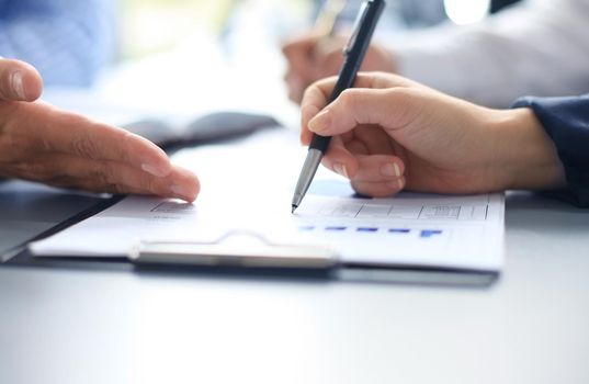 Unrecognizable business person analyzing graphs and taking notes