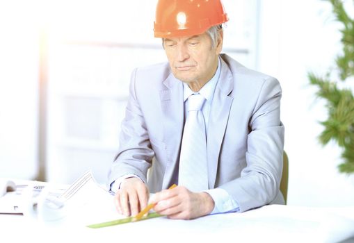 Engineer at the age of considering plans drawing and corrects them.