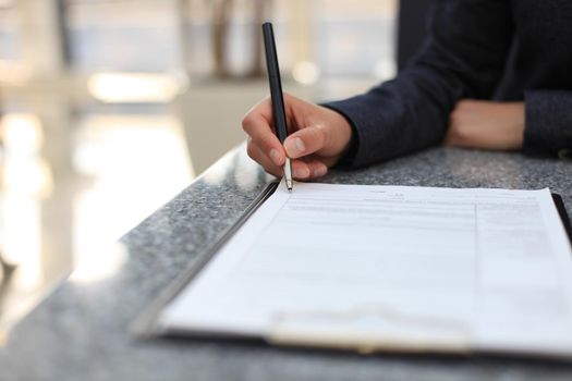 Close-up of Businesswoman makes a note at business document