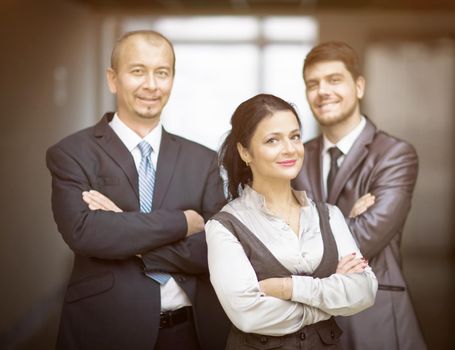 Smiling employees standing behind each other in the office
