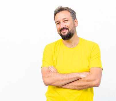 One positive man with yellow shirt portrait against wall