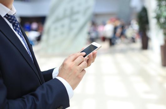 Close up of a business man using mobile smart phone