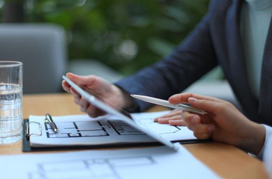 Real-estate agent showing house plans on electronic tablet