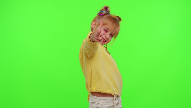 Stylish kid girl making trendy dance video for social media network, child dancing, blogger fun activity challenge, children hobbies games after school. Schoolgirl child on green chroma key background