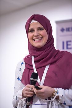 young muslim businesswoman at business conference room with public giving presentations. Audience at the conference hall. Entrepreneurship club