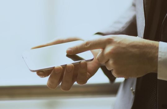 Close up of a man using mobile smart phone outdoor