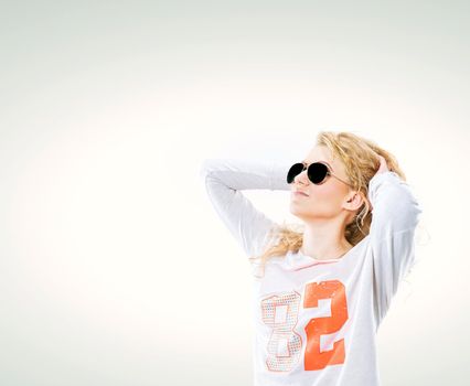 beautiful young blond woman in dark glasses and a white sweater