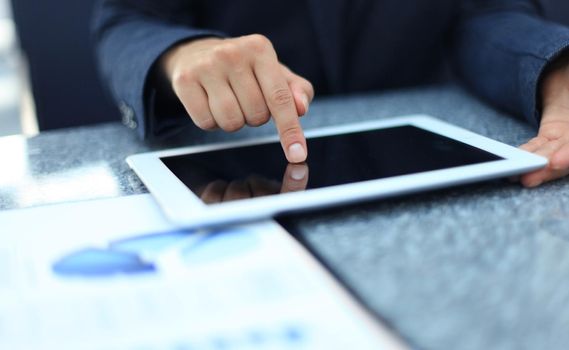 Woman hand touching screen on modern digital tablet pc. Close-up image with shallow depth of field focus on finger.