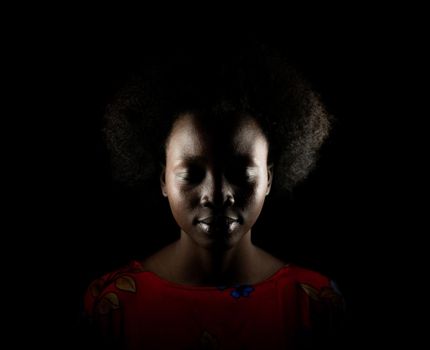 Dark portrait of young black woman in studio