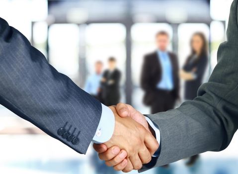 Business associates shaking hands in office