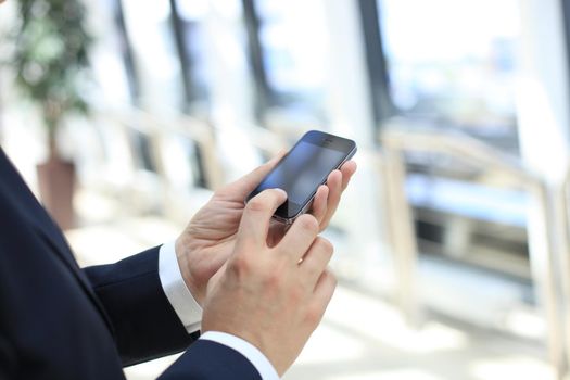 Close up of a business man using mobile smart phone