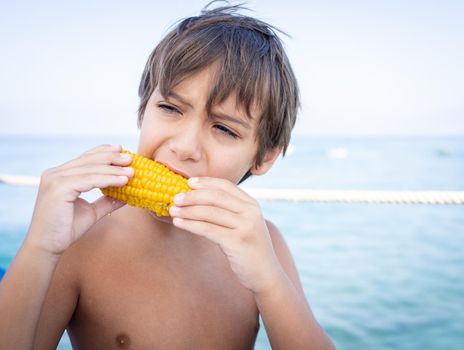 Boy sitting on beach pier and eating