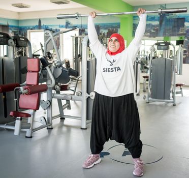 Arabic woman active working out in big gym