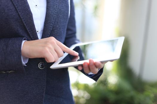 Close-up of businesswoman holding digital tablet and cup coffee