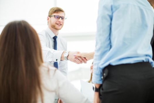 Bank Manager and the customer shake hands after signing a lucrative contract on the background of the modern office