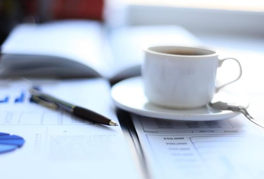 Office supplies and coffee cup on table