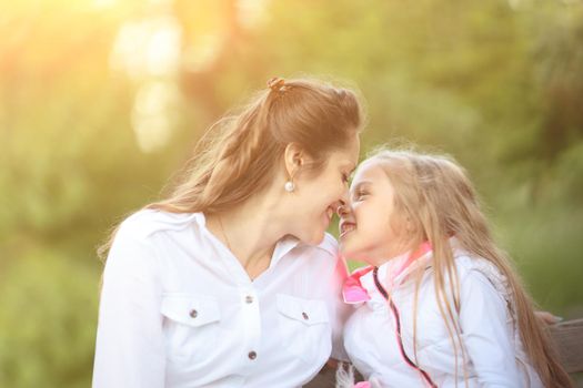 portrait of mother and daughter against the background of the Park on a Sunny day