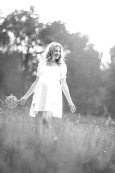 happy pregnant woman walking in the Park on a Sunny day. Black and white photo