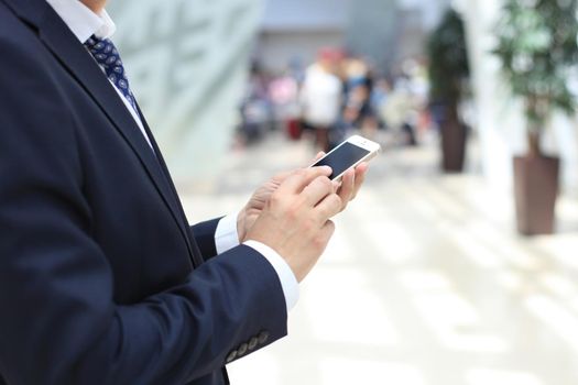Close up of a business man using mobile smart phone