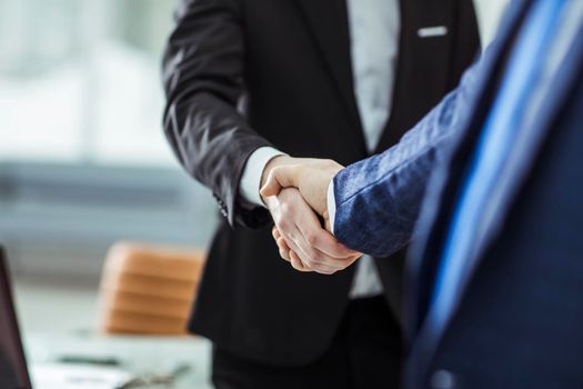 closeup of handshake of business partners on the background of bright office.