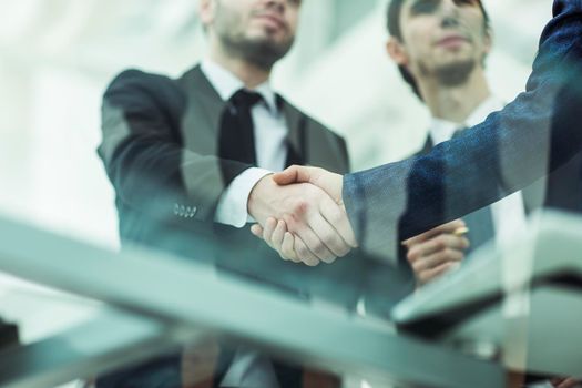 closeup of handshake of business partners on background of office