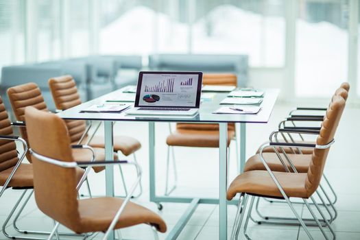 modern workplace with open laptop and financial documents prepared for meeting business partners. the photo is a blank space for your text