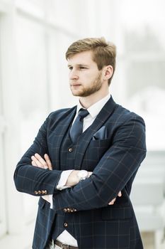 newcomer businessman in a business suit stands near the window, hands folded in front of him .the photo has a empty space for your text