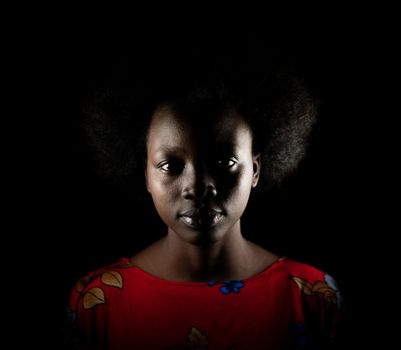 Dark portrait of young black woman in studio