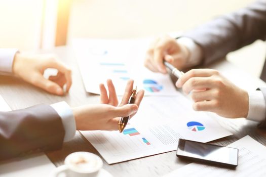 Image of two young businessmen discussing document at meeting