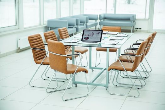 open laptop computer with financial charts and papers spread out on the desktop before starting business negotiations. the photo is a blank space for your text