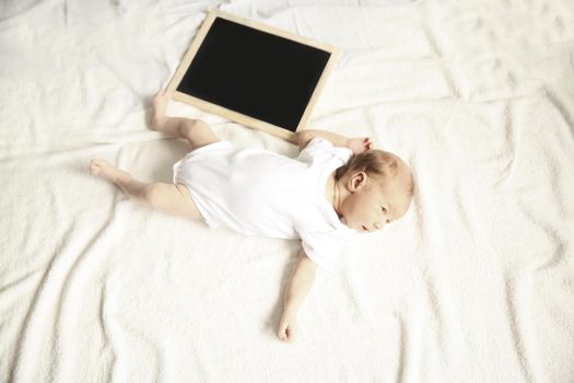portrait of a newborn baby and a birthday card on a light background.the photo has a empty space for your text