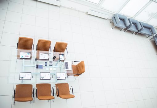 top view - a place for business meetings in the modern conference room. on the desktop, spread out financial charts,calculators and laptop. the photo is a blank space for your text