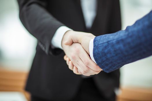 closeup of handshake of business partners on the background of bright office.