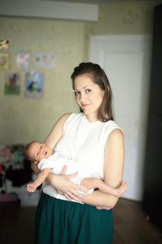 young mother with a newborn baby in the nursery