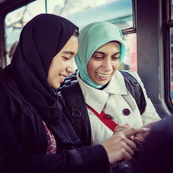 Mother and daughter riding public transport in the city